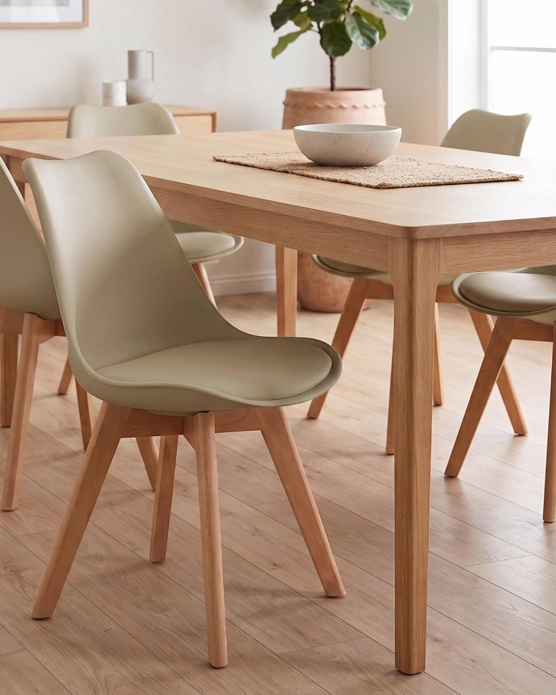 Dining room with wooden table and taupe chairs on a wooden floor
