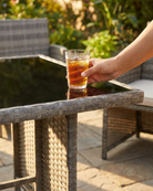 Glass of iced tea on a patio table with glass top