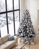 An 8ft white Christmas tree decorated with berries and pine cones in the living room