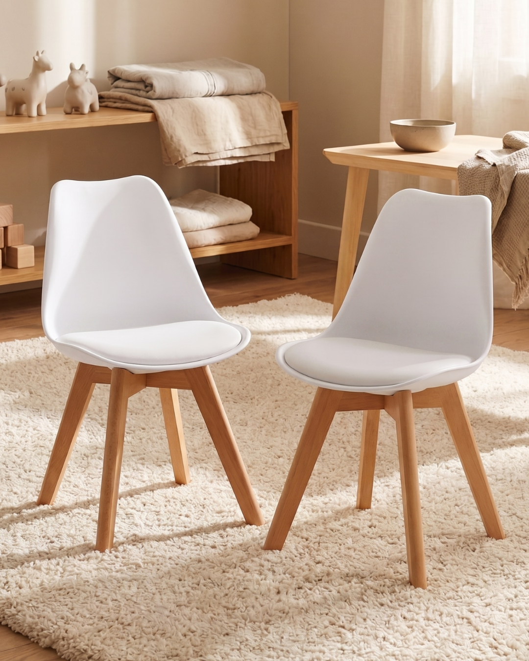 Two white tulip chairs with wooden legs in a nursery room