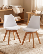 Two white tulip chairs with wooden legs in a nursery room